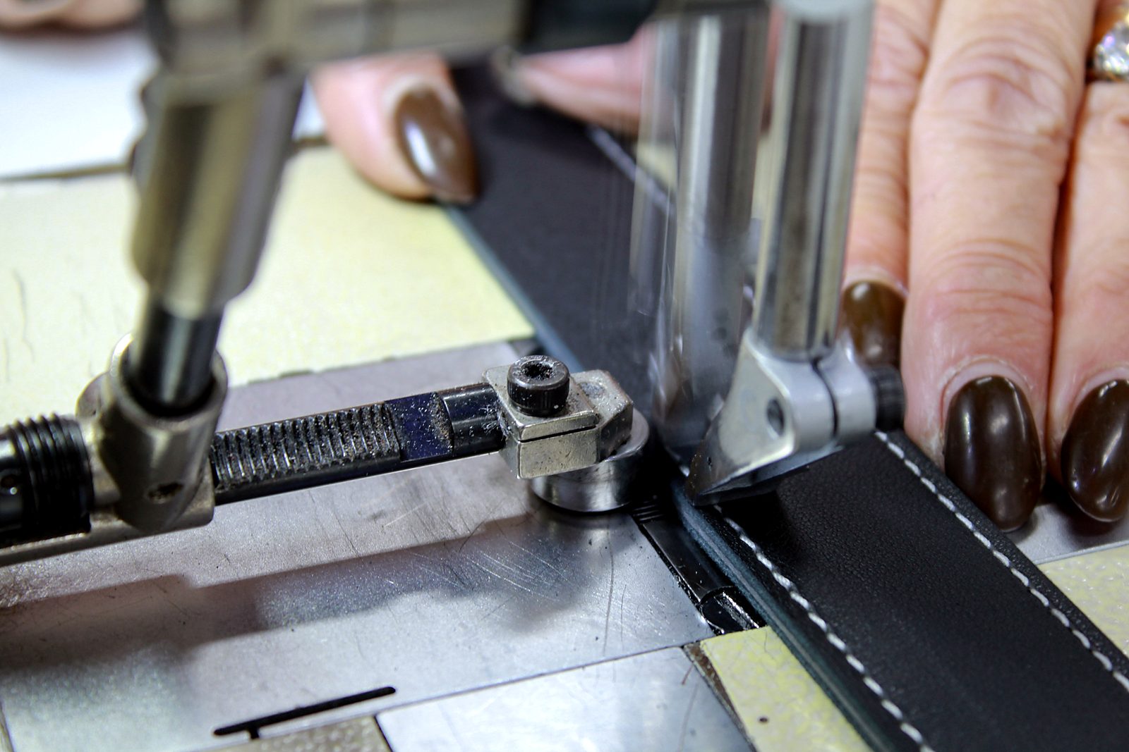 Stitching a black leather belt with white thread
