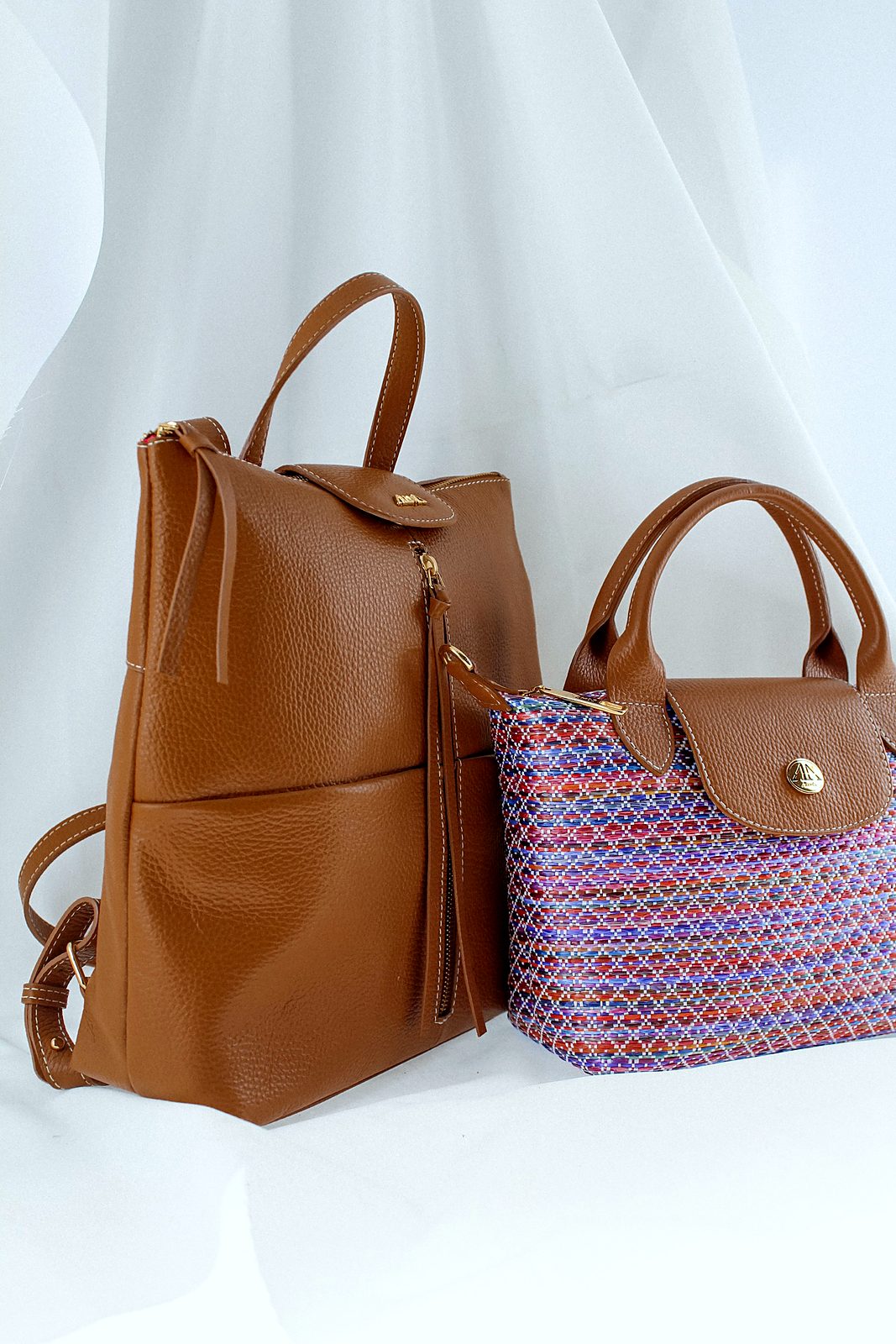 Tan leather backpack and a small woven handbag